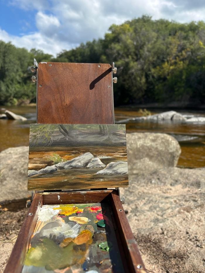 Óleo sobre madera del río de Córdoba, apoyado en el caballete frente al río