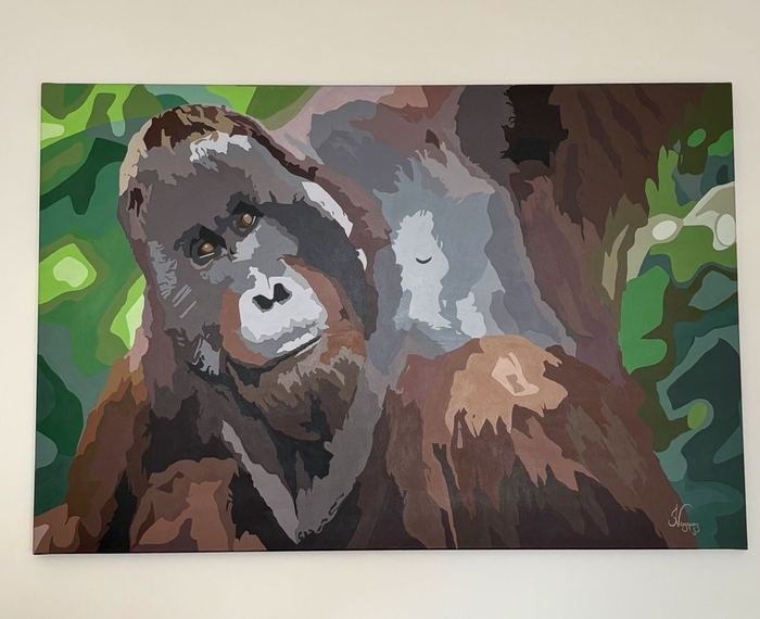 Pintura de un orangután entre hojas verdes, colgada en una pared