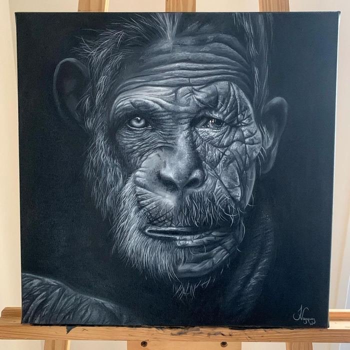 Óleo en blanco y negro de un simio de mirada humana, sobre caballete